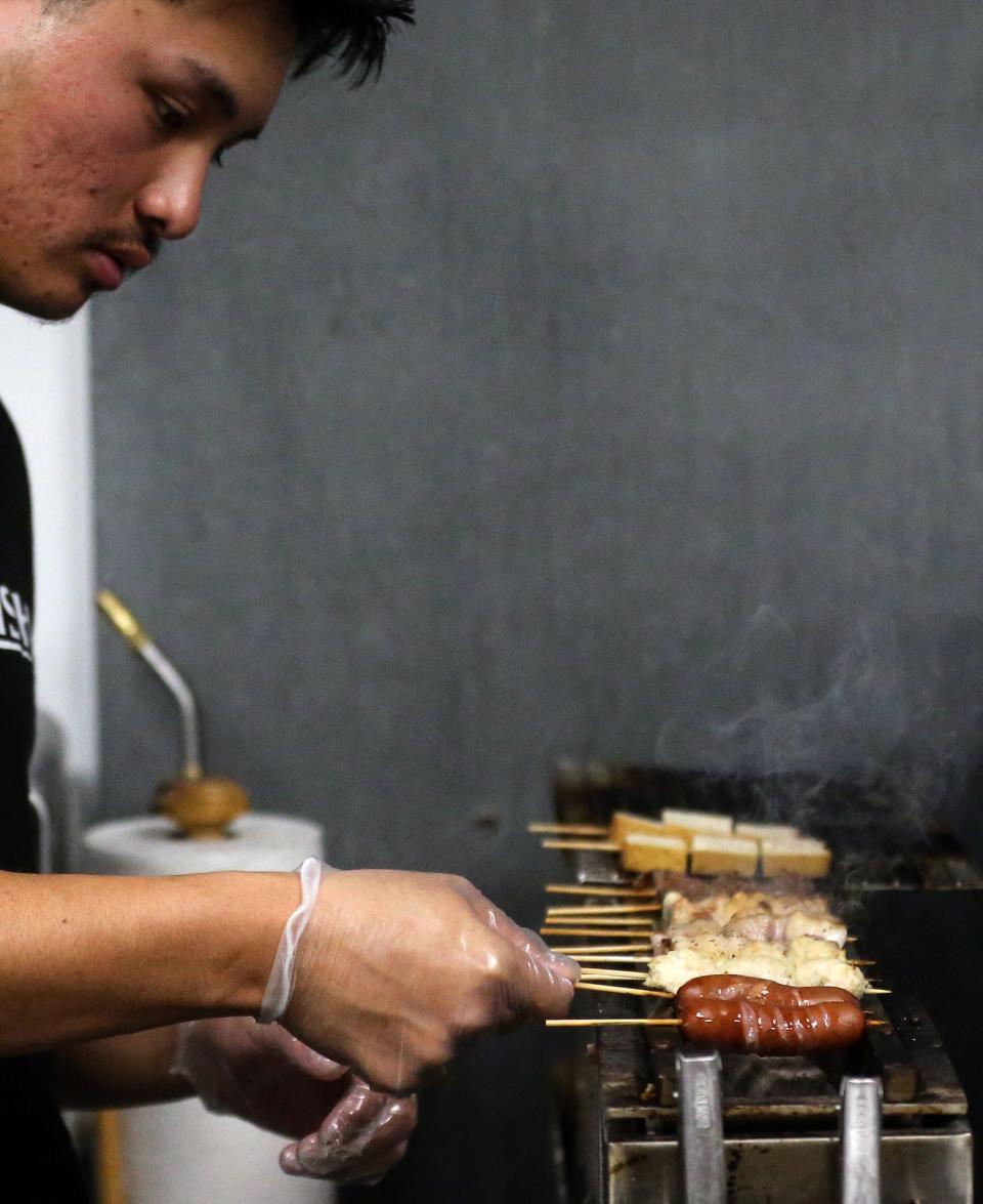 Micah Springfield cooks a variety of yakitori over a charcoal grill at Oishi Japanese Kitchen in Bremerton on Monday, Nov. 20, 2023.