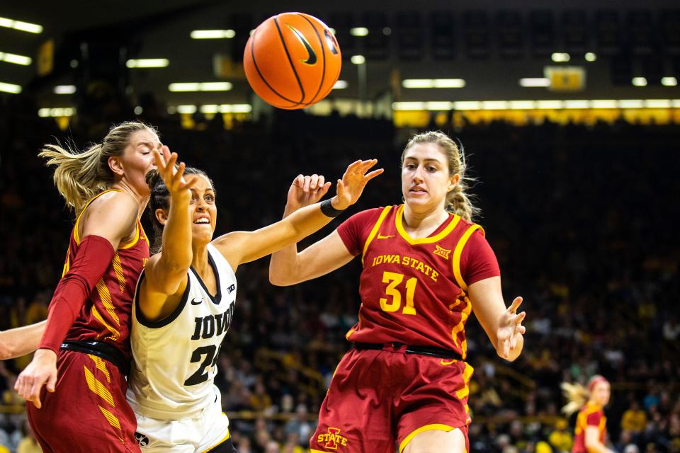 Iowa guard Gabbie Marshall, second from left, reaches for a loose ball against Iowa State's Morgan Kane, right, and Ashley Joens during Wednesday's game at Carver-Hawkeye Arena.