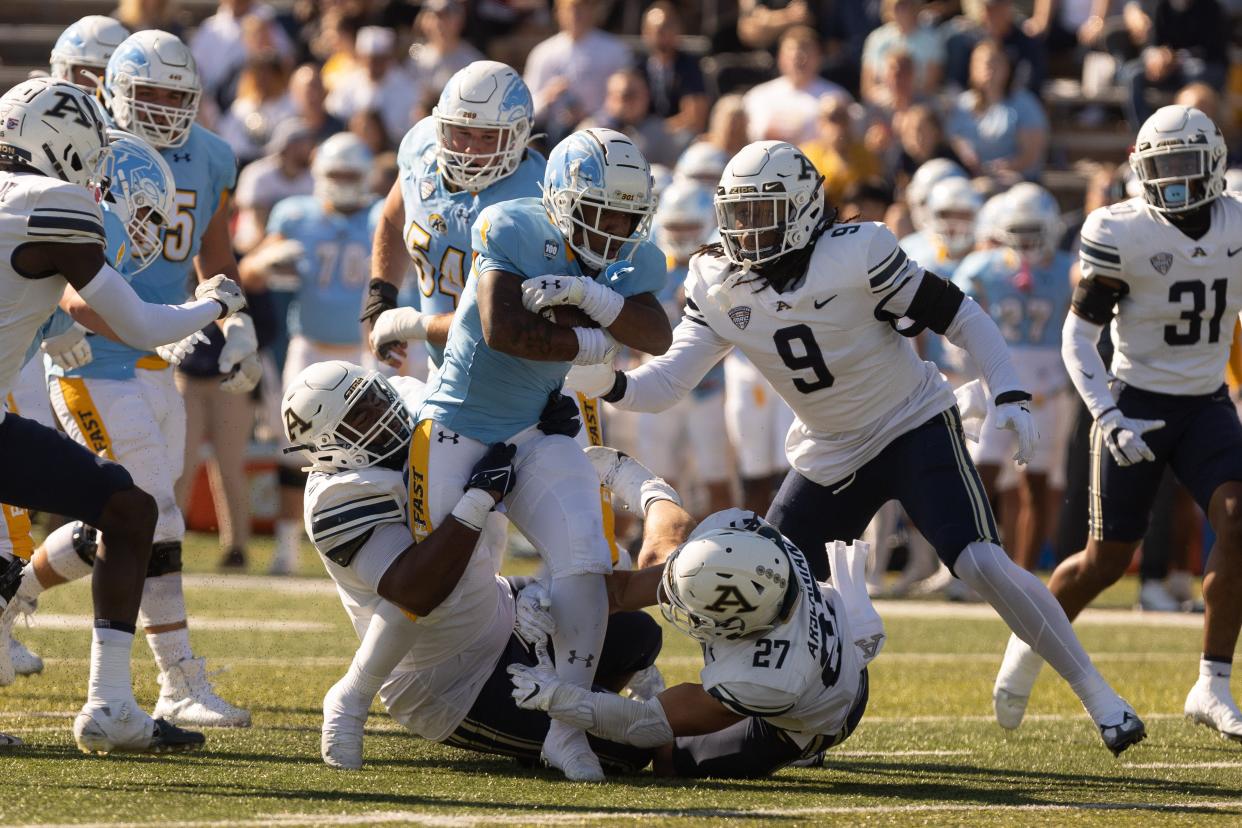 Kent State running back Marquez Cooper drives through the line in the first half of Saturday’s game against the Akron Zips.