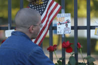 INDIANAPOLIS, IN - OCTOBER 17: James Allen looks over tributes to two-time Indianapolis 500 winner Dan Wheldon which have been left behind at a memorial at the gate of the Indianapolis Motor Speedway on October 17, 2011 in Indianapolis, Indiana. Wheldon, winner of the 2011 Indy 500, was killed in a crash yesterday at the Izod IndyCar series season finale at Las Vegas Motor Speedway. (Photo by Scott Olson/Getty Images)