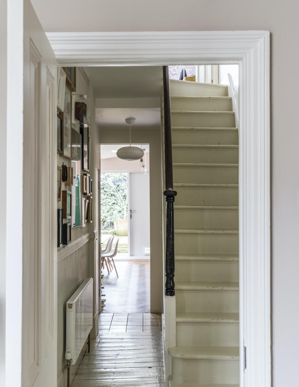 A neutral entryway with dark wood bannister and details.
