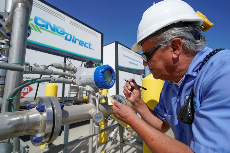 A Calgren worker checks the flow of incoming compressed methane from a dairy farm at the company's facility in Pixley, California