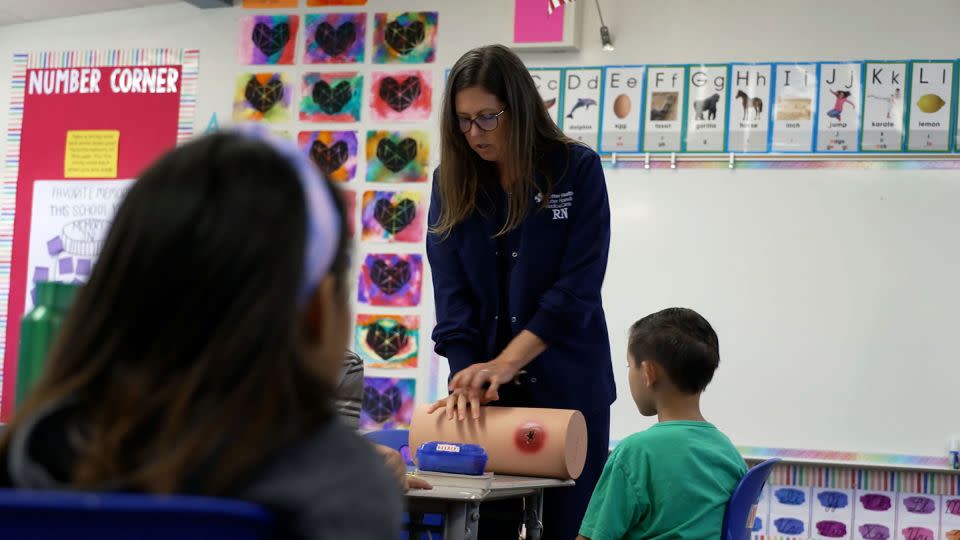 Kate Carleton, center, teaches children at a California elementary school how to stop a wound from bleeding out. - CNN