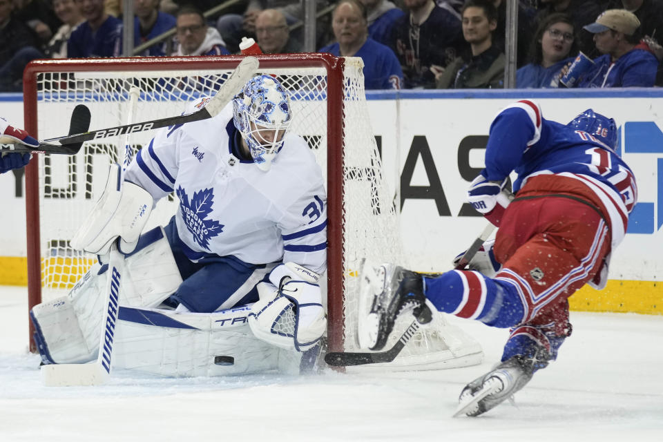 New York Rangers' Vincent Trocheck, right, falls as he takes on shot on Toronto Maple Leafs goaltender Martin Jones during the third period of an NHL hockey game, Tuesday, Dec. 12, 2023, in New York. (AP Photo/Seth Wenig)