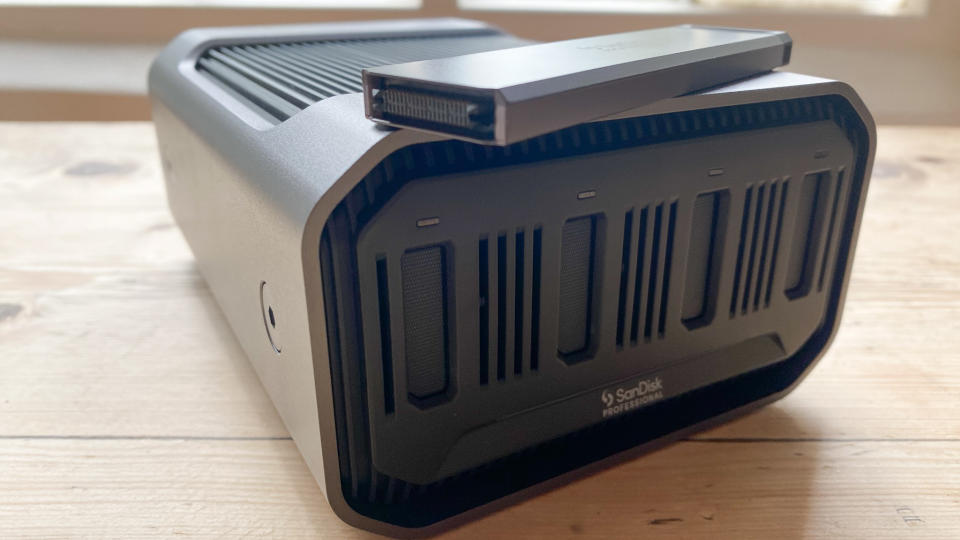 A SanDisk Professional Pro-Blade Station sitting on a wooden desk