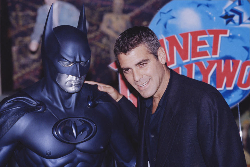 George Clooney poses with a model of Batman during a photocall for "Batman and Robin" at Planet Hollywood in 1997. (Photo: Colin Davey via Getty Images)