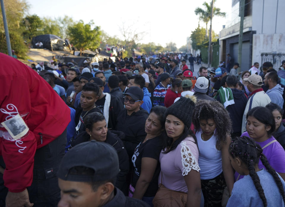 Venezuelan migrants line up to receive a ticket for a date application for asylum in the U.S., in Matamoros, Mexico, Thursday, Dec. 22, 2022. (AP Photo/Fernando Llano)