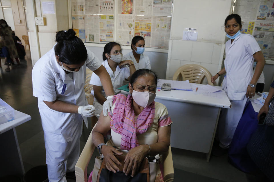 A woman reacts as she receives a shot of the Covishield COVID-19 vaccine at Sola Civil hospital in Ahmedabad, India, Wednesday, March 3, 2021. The COVID-19 vaccination drive for senior citizens and those above 45 years of age with comorbidities began in government and designated private hospitals in Gujarat on Monday along with the rest of the country. (AP Photo/Ajit Solanki)