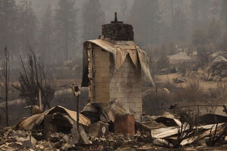 Rubble from a burnt home is pictured near Alta Lake Golf Course after much of the area was consumed by the Carlton Complex Fire near Pateros, Washington July 19, 2014. The wildfire raging unchecked for a sixth day east of Washington state's Cascade Mountains has destroyed about 100 homes, displaced hundreds of residents and left thousands without electricity, emergency officials said on Saturday. REUTERS/David Ryder