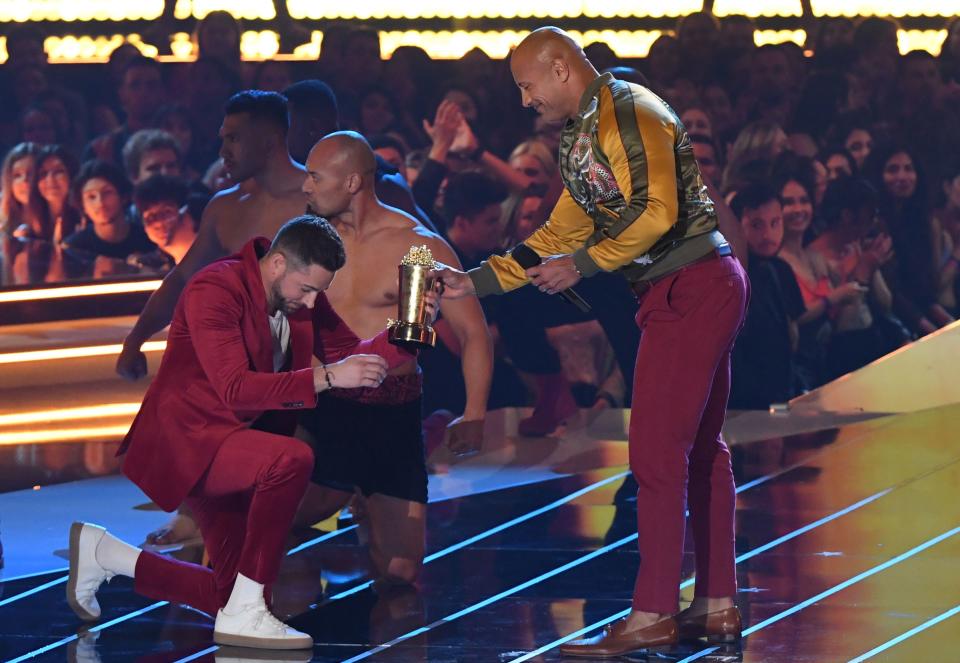 US actor Dwayne Johnson (R) accepts his Generation Award from host US actor Zachary Levi onstage during the 2019 MTV Movie & TV Awards at the Barker Hangar in Santa Monica on June 15, 2019. - The 2019 MTV Movie & TV Awards were filmed on June 15 and air on June 17. (Photo by VALERIE MACON / AFP)        (Photo credit should read VALERIE MACON/AFP via Getty Images)