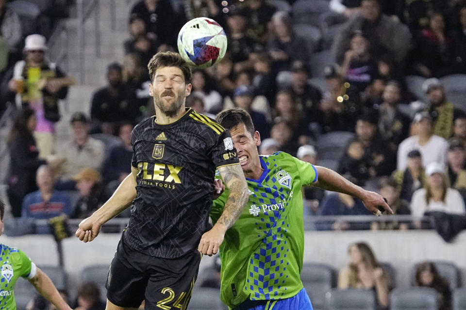 Los Angeles FC midfielder Ryan Hollingshead, left, heads the ball as Seattle Sounders defender Jackson Ragen tries during the first half of a Major League Soccer match Wednesday, June 21, 2023, in Los Angeles. (AP Photo/Mark J. Terrill)