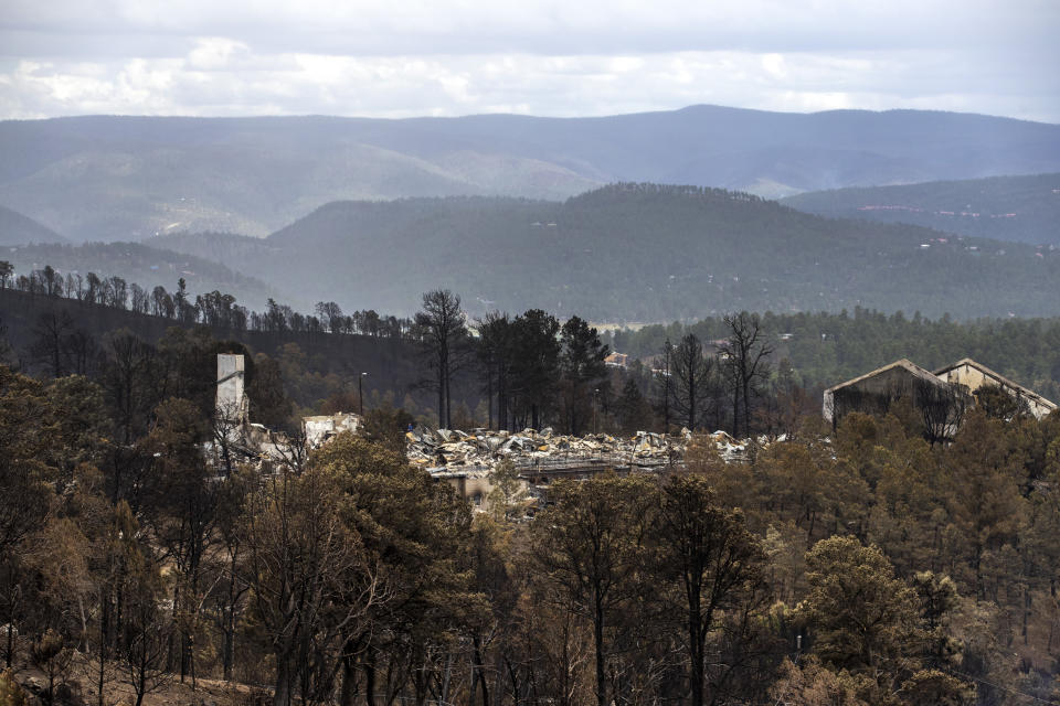 The flattened remains of the Swiss Chalet Hotel are shown after it was destroyed by the South Fork Fire in the mountain village of Ruidoso, N.M., Saturday, June 22, 2024. (AP Photo/Andres Leighton)