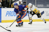 New York Islanders center Mathew Barzal (13) skates with the puck in front of Pittsburgh Penguins center Jared McCann (19) during the second period of an NHL hockey game, Sunday, Feb. 28, 2021, in Uniondale, N.Y. (AP Photo/Kathy Willens)