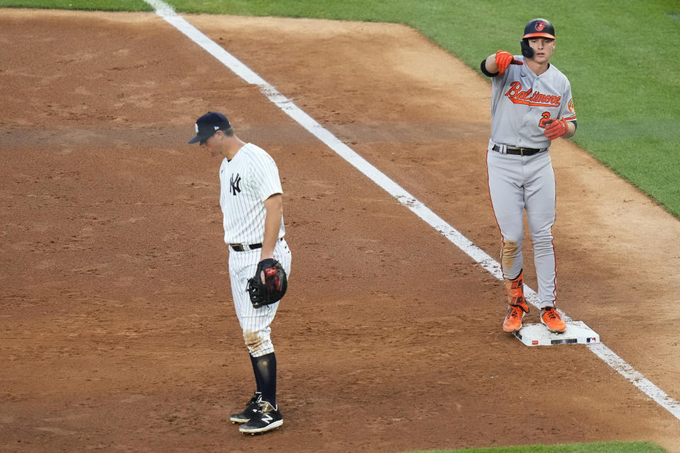 Baltimore Orioles' Gunnar Henderson (2) gestures to teammates after hitting an RBI single, near New York Yankees first baseman DJ LeMahieu during the third inning of a baseball game Thursday, July 6, 2023, in New York. (AP Photo/Frank Franklin II)