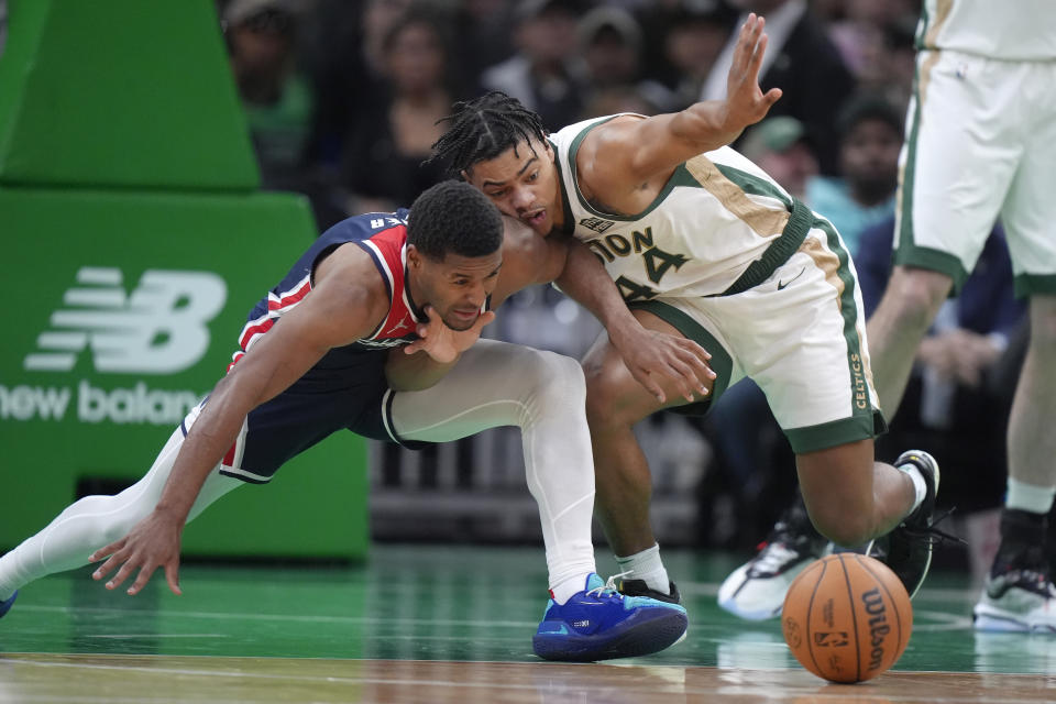 Washington Wizards guard Jared Butler, left, and Boston Celtics guard Jaden Springer, right, pursue a loose ball in the first half of an NBA basketball game, Sunday, April 14, 2024, in Boston. (AP Photo/Steven Senne)