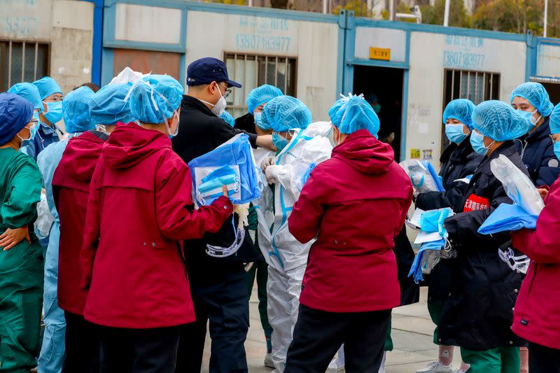 Medical worker puts on protective suit before entering a sports centre which has been converted into a makeshift hospital to treat patients of the novel coronavirus, in Wuhan