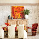 <p>Even a stone wall feels warm and beach house-appropriate when it’s whitewashed. The texture of the stone roots the space in warmth and a feeling of age, while off-white linen slipcovers, blond woods, and light floors contribute to the room’s bright, airy look.</p> <p><strong>Idea Spotlight</strong></p> <p>Shop locally to find pieces that will give your house a sense of place. In this Los Cabos, Mexico, dining room, the designer brought in a colorful host chair and a vibrant painting from local shops to reflect a Mexican sensibility.</p>