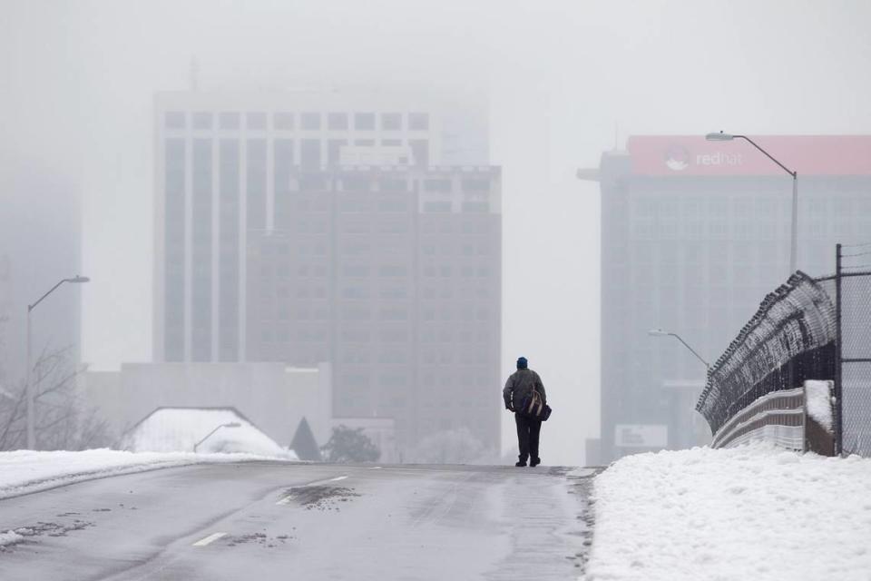 Downtown Raleigh is covered in dense clouds during day two of a winter storm as a man walks across the Wilmington Street bridge on Thursday morning February 13, 2014 in Raleigh, N.C. Robert Willett/rwillett@newsobserver.com