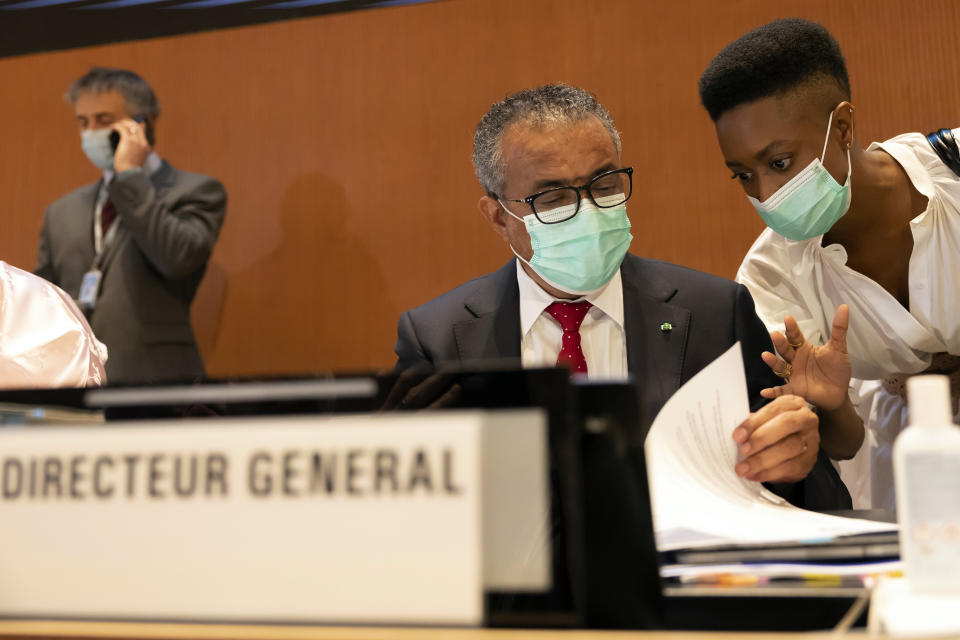 Tedros Adhanom Ghebreyesus, left, Director General of the World Health Organization (WHO), talks with a member of staff during the first day of the 75th World Health Assembly at the European headquarters of the United Nations in Geneva, Switzerland, Sunday, May 22, 2022. (Salvatore Di Nolfi/Keystone via AP)