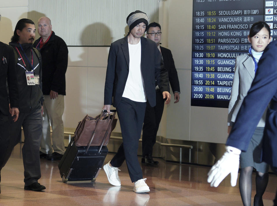 Seattle Mariners' Ichiro Suzuki, center, walks upon his team's arrival at Haneda international airport in Tokyo Friday, March 15, 2019. The Mariners will play in a two-baseball game series against the Oakland Athletics to open the Major League season on March 20-21 at the Tokyo Dome. (AP Photo/Eugene Hoshiko)