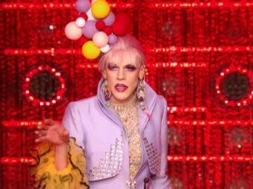 Utica on stage of "drag race" wearing a head piece made of balls