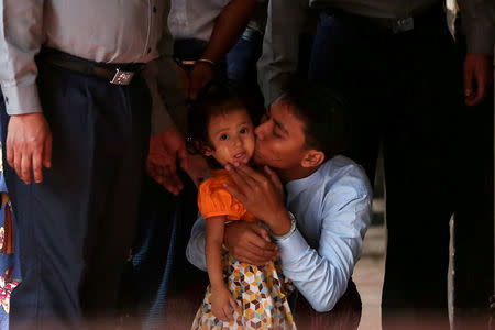 Detained Reuters journalist Kyaw Soe Oo kisses his daughter as he is escorted by police for a court hearing in Yangon, Myanmar, February 21, 2018. REUTERS/Stringer