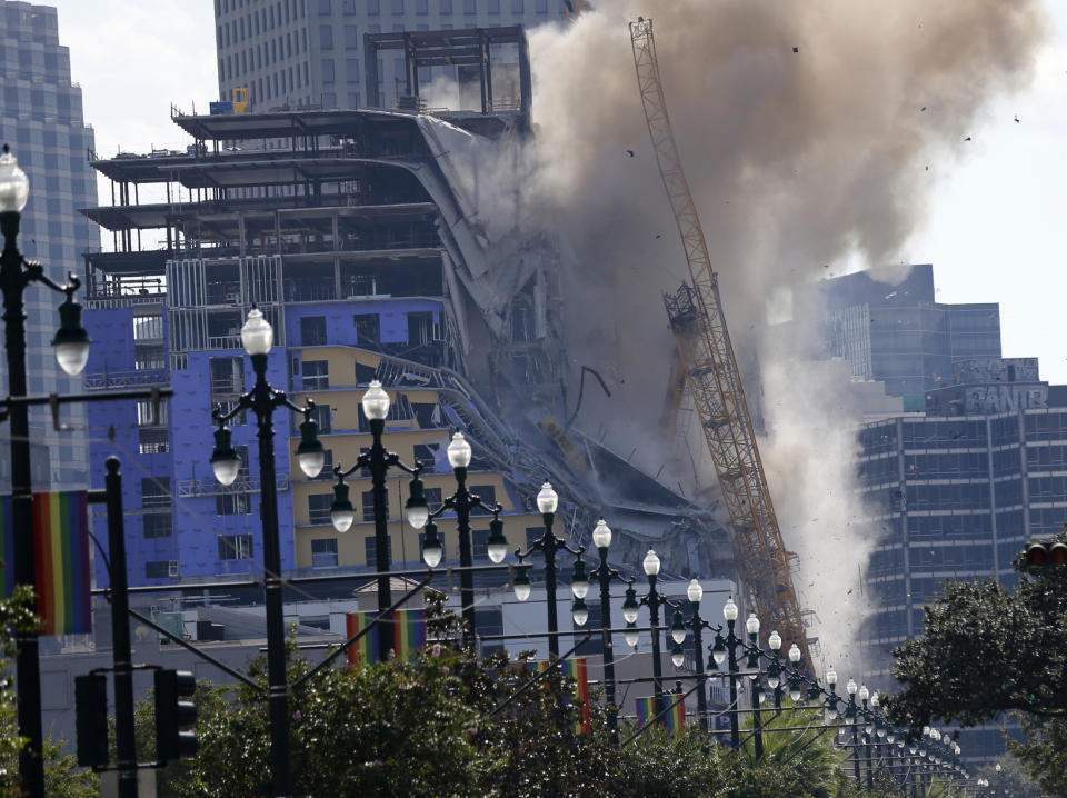 Two large cranes from the Hard Rock Hotel construction collapse come crashing down after being detonated for implosion in New Orleans, Sunday, Oct. 20, 2019. New Orleans officials set off several explosions Sunday intended to topple two cranes that had been looming over the ruins of a partially collapsed hotel. (AP Photo/Gerald Herbert)