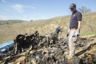 FILE - In this Jan. 27, 2020, file photo, provided by the National Transportation Safety Board, NTSB investigators Adam Huray, right, and Carol Hogan examine wreckage as part of the NTSB's investigation of a helicopter crash near Calabasas, Calif. Federal investigators said Wednesday, June 17, 2020, that the pilot of the helicopter that crashed in thick fog, killing Kobe Bryant and seven other passengers, reported he was climbing when he actually was descending. (James Anderson/National Transportation Safety Board via AP, File)