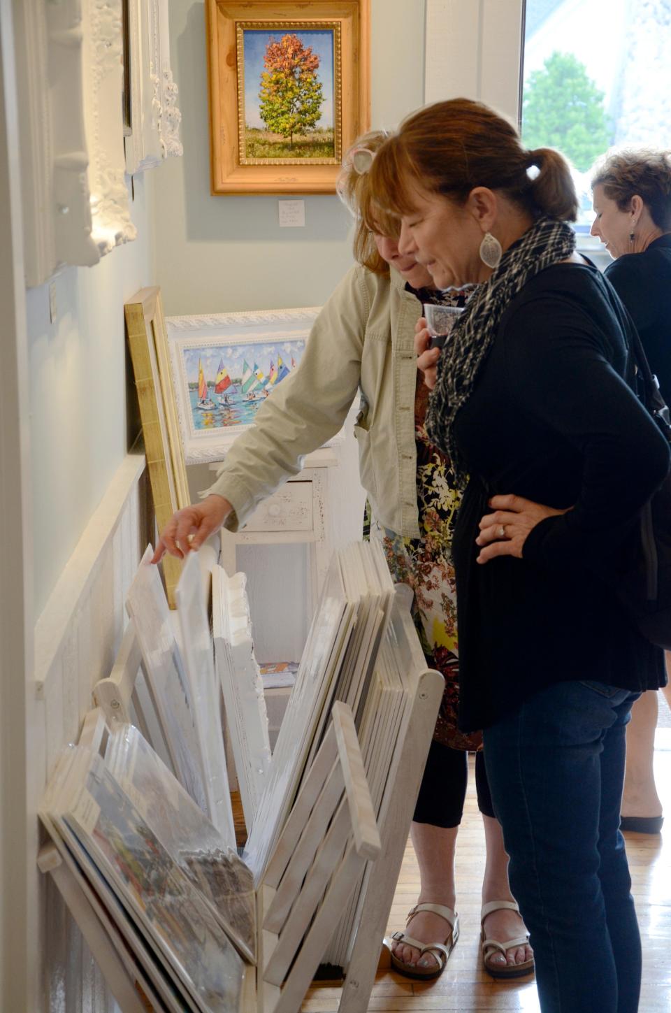 Gallery walk participants browse through prints at Witty Art Galerie during the 2019 Night of the Arts in Harbor Springs.