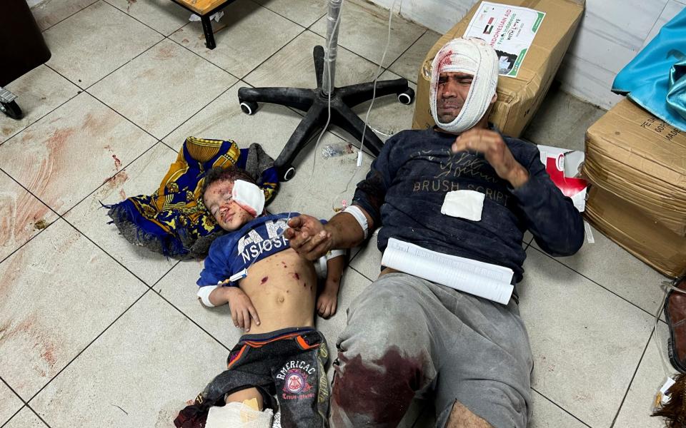 Palestinians wounded in Israeli strikes lie on the floor at the Indonesian hospital
