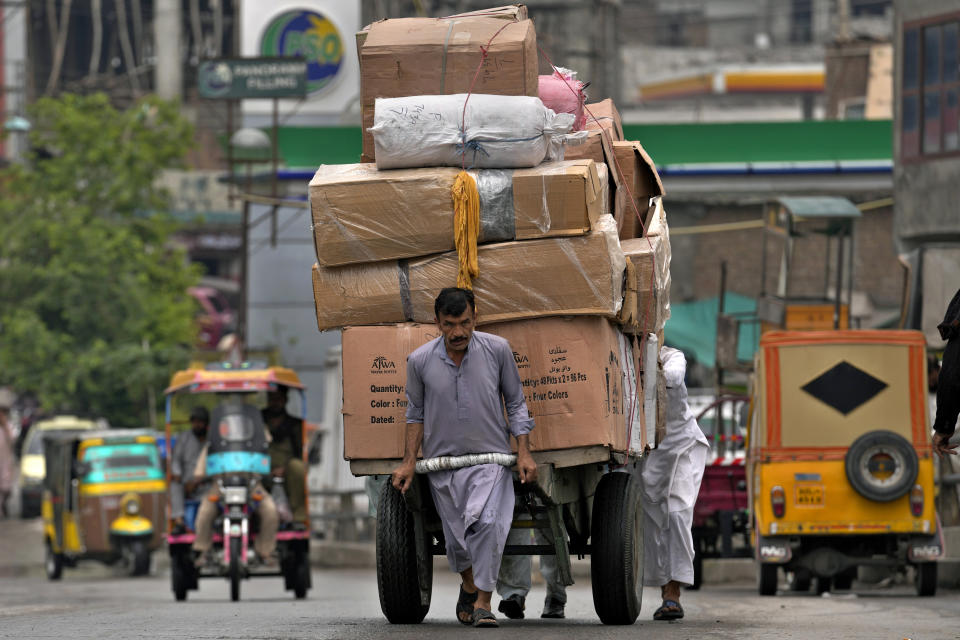 Laborer pull a heavy loaded hand-cart on a road on the International Labor Day, in Rawalpindi, Pakistan, Monday, May 1, 2023. In Pakistan, authorities have banned rallies in some cities due to a tense security situation or political atmosphere. Labor organizations and trade unions held indoor events on May Day to demand implementation of labor laws and increase in their wages. (AP Photo/Anjum Naveed)