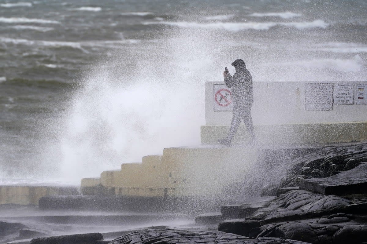 A man takes photos of the waves at Blackrock Diving Board, Salthill, Co. Galway (PA)