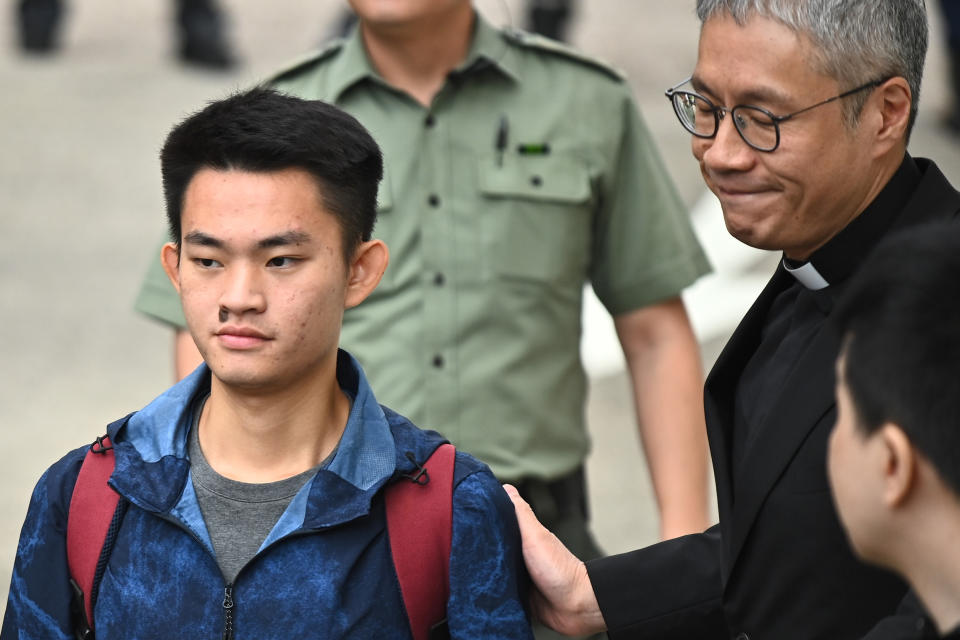 Chan Tong-kai (L), 20, wanted in Taiwan for the murder of his pregnant girlfriend during a holiday the two Hong Kongers took there in 2018, is greeted by Reverend Peter Koon Ho-ming (R) as he walks out the Pik Uk Prison in Hong Kong on October 23, 2019, after serving a short jail sentence for stealing his girlfriend's possessions. - Chan's case, where he fled back to Hong Kong where Taiwanese police were unable to apprehend him because there is no extradition agreement between the two territories, triggered an ill-fated proposal by Hong Kong's pro-Beijing government to ram through a sweeping extradition bill, which would have allowed the city to extradite suspects to any territory including the authoritarian mainland. (Photo by Philip FONG / AFP) (Photo by PHILIP FONG/AFP via Getty Images)