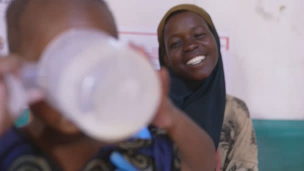 PHOTO: Garan Hassan smiles as her child Nadifa finally drinks at the hospital. (ABC News)