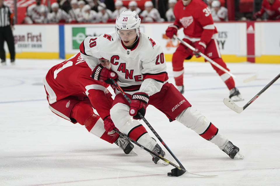 Carolina Hurricanes right wing Sebastian Aho (20) protects the puck from Detroit Red Wings center Dylan Larkin (71) in the second period of an NHL hockey game Sunday, March 14, 2021, in Detroit. (AP Photo/Paul Sancya)