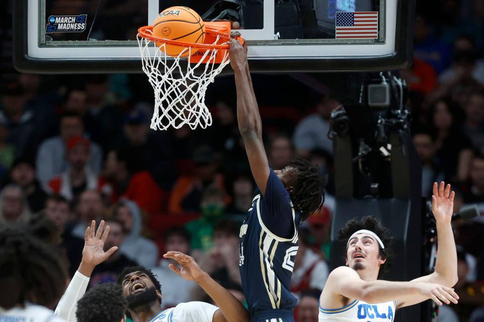 Akron forward Ali Ali, center, dunks over UCLA forward Cody Riley, left, and UCLA guard Jaime Jaquez Jr., right, during a first-round NCAA college basketball tournament game March 17, 2022, in Portland, Ore.