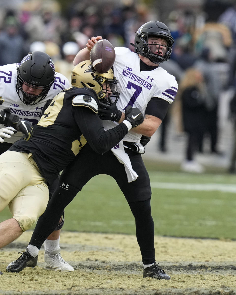 Northwestern quarterback Cole Freeman (7) fumbles as he's sacked by Purdue defensive end Jack Sullivan (99) at the end of the fourth quarter in an NCAA college football game in West Lafayette, Ind., Saturday, Nov. 19, 2022. Purdue defeated Northwestern 17-9. (AP Photo/Michael Conroy)