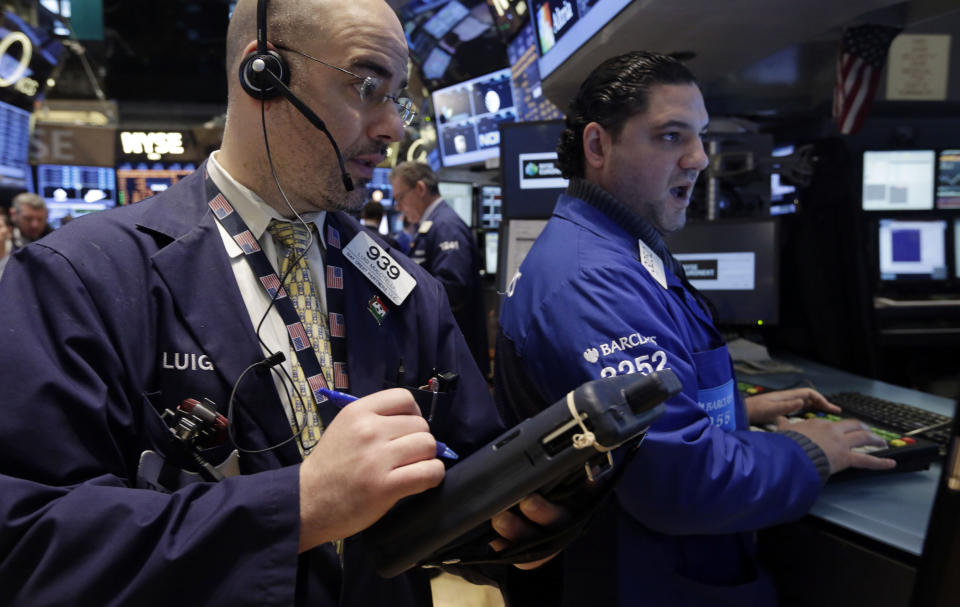 Trader Luigi Muccitelli, left, and specialist Ronnie Howard work on the floor of the New York Stock Exchange Wednesday, Feb. 5, 2014. The U.S. stock market is edging lower in early trading after a modest recovery the day before. (AP Photo/Richard Drew)