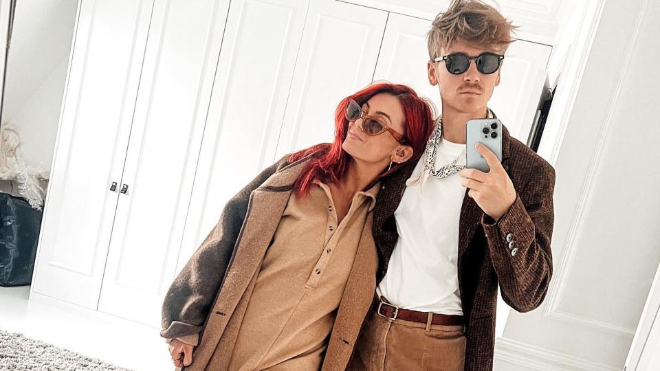 Dianne Buswell and Joe Sugg posing in front of a mirror in matching clothes