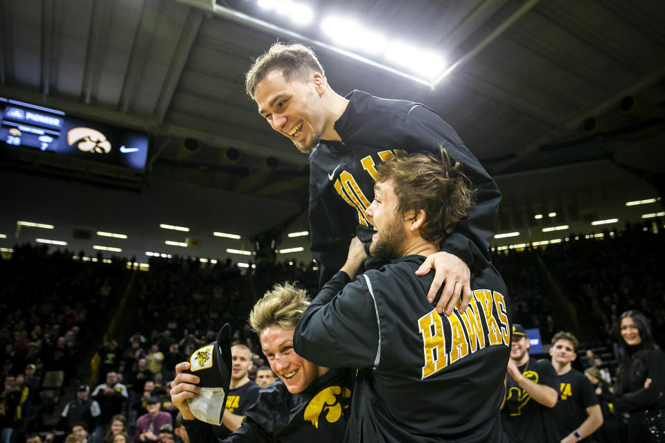 FILE - Iowa's Spencer Lee is lifted up onto the shoulders of teammates Max Murin, left, and Jacob Warner as they are acknowledged on senior day after a college wrestling dual against Oklahoma State, Sunday, Feb. 19, 2023, in Iowa City, Iowa. Iowa 125-pounder Spencer Lee has a chance to win his fourth national title this weekend at the NCAA wrestling championships in Tulsa, Oklahoma(Joseph Cress/Iowa City Press-Citizen via AP, File)