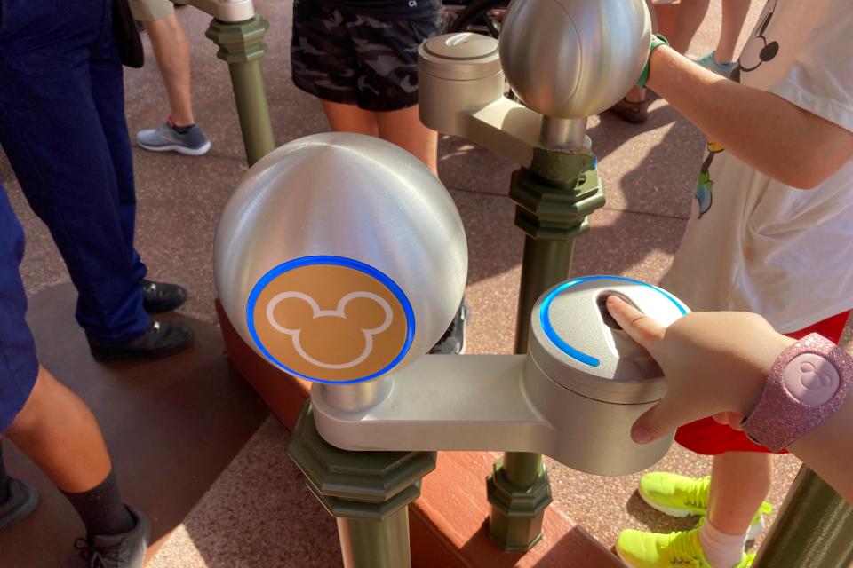 Guests scan fingerprints and Magic Bands to electronically verify valid admission at Magic Kingdom on April 18, 2022.