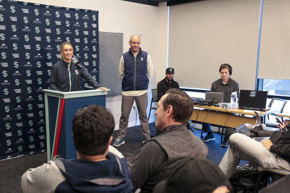 Seattle Kraken new assistant coach Jessica Campbell, left, speaks, as Kraken head coach Dan Bylsma, center, listens during an NHL hockey press conference Wednesday, July 3, 2024, in Seattle. Campbell will become the first woman to work on the bench of an NHL franchise after the team hired her as an assistant coach. (AP Photo/Jason Redmond)