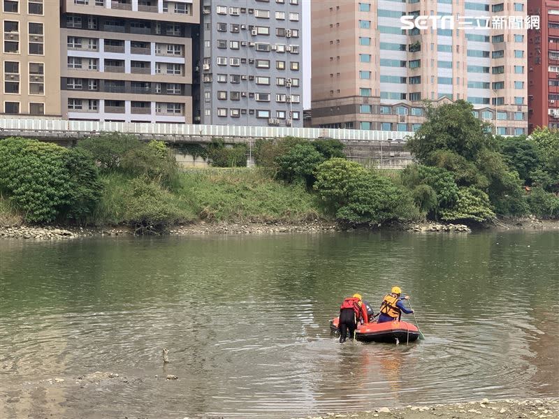 消防人員華著橡皮艇在新店溪流域搜救。（圖／翻攝畫面）