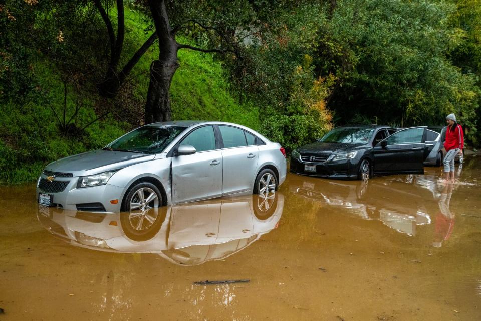 Cars sit on flooded street along hillside at 3700 block of North Fredonia Drive