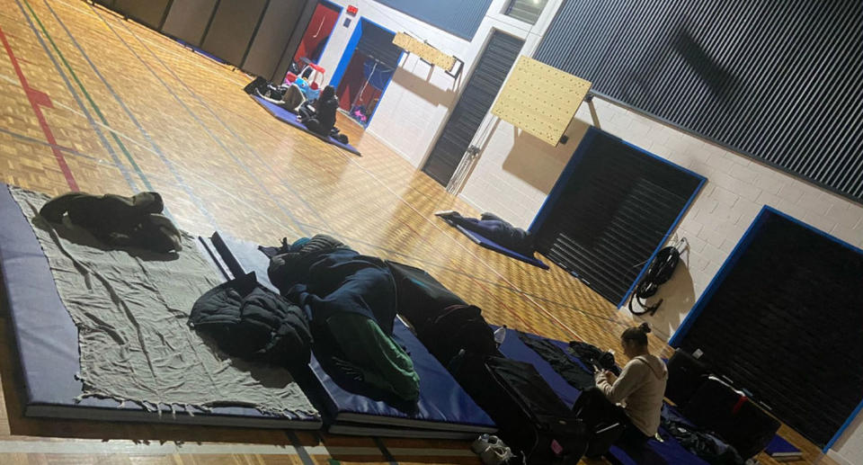 people sleeping on mats on a gym floor