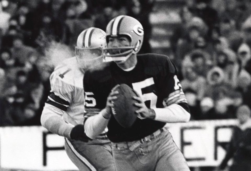 Green Bay Packers quarterback Bart Starr is chased by Dallas Cowboys defensive tackle Willie Townes during the 1967 NFL championship game at Lambeau Field.
