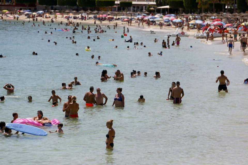 People sunbathe at Magaluf beach in Mallorca, Spain (REUTERS)