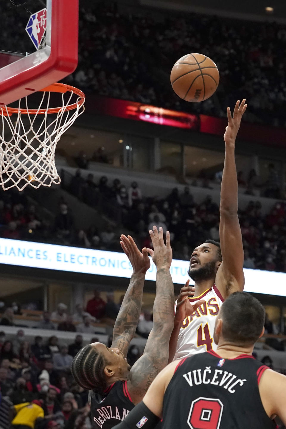 Cleveland Cavaliers' Evan Mobley (4) shoots over Chicago Bulls' DeMar DeRozan as Nikola Vucevic (9) watches during the first half of an NBA basketball game Wednesday, Jan. 19, 2022, in Chicago. (AP Photo/Charles Rex Arbogast)