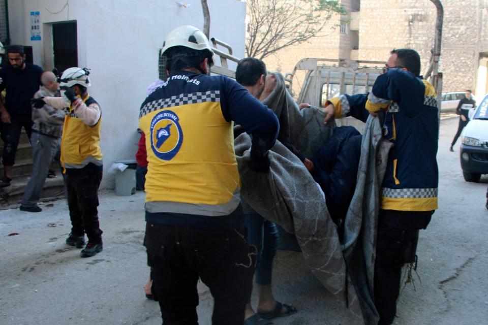 This photo provided by the Syrian Civil Defense White Helmets, which has been authenticated based on its contents and other AP reporting, shows Syrian White Helmet civil defense workers carrying a casualty, in the northern town of Ariha, in Idlib province, Syria, Wednesday, Oct. 20, 2021 (AP)