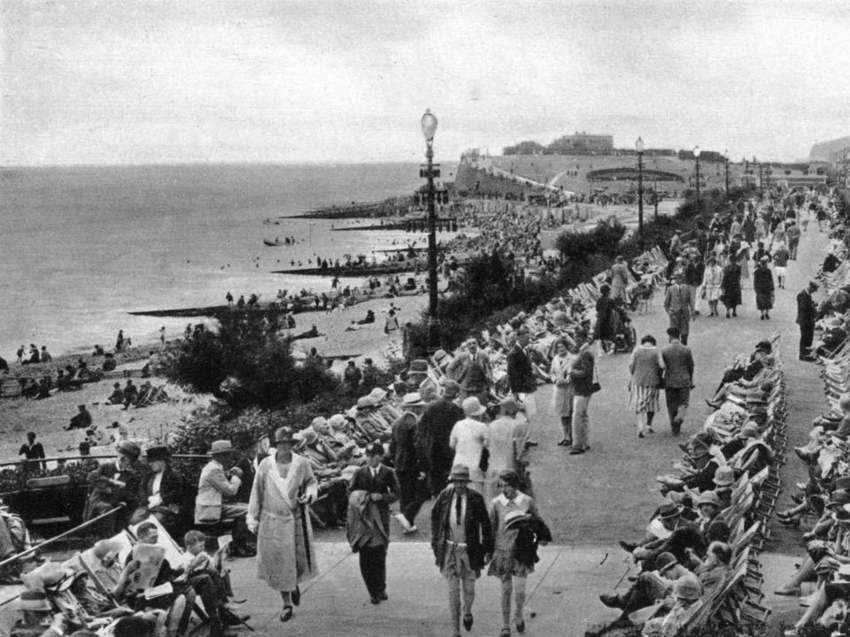 A busy outdoor parade by the sea.